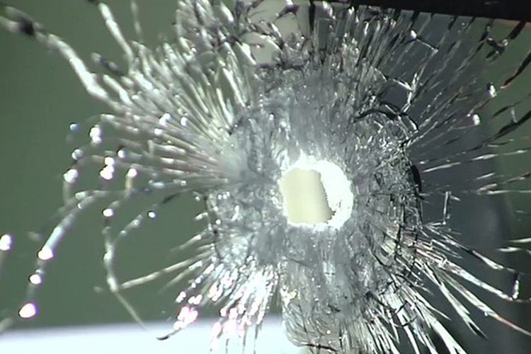Foto mostra vidro estilhaçado na sede da Polícia FEderal em Goiânia, depois de um tiroteio