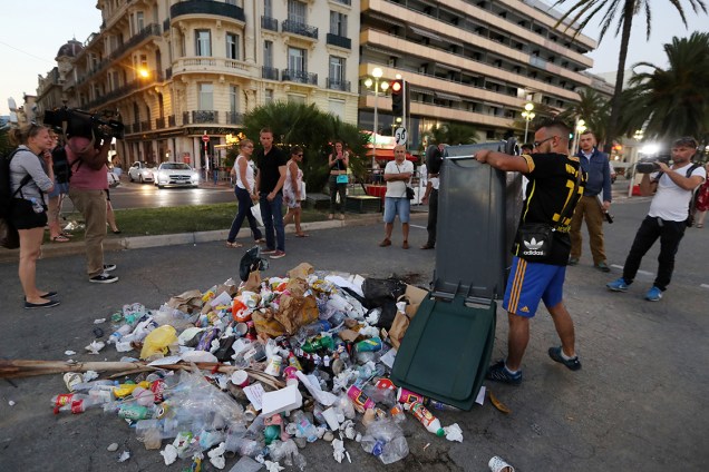 População francesa faz "memorial de ódio" no local onde o atirador de Nice foi morto pela polícia no Dia da Bastilha. Na foto, homem revira uma lata de lixo como forma de protesto - 19/07/2016