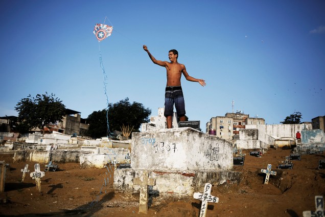 Garoto empina pipa em um cemitério na favela da Vila Operária, no Rio de Janeiro - 20/07/2016