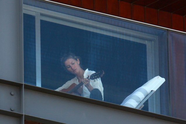 Gisele Bündchen é fotografada tocando violão na sacada do hotel Fasano em São Paulo