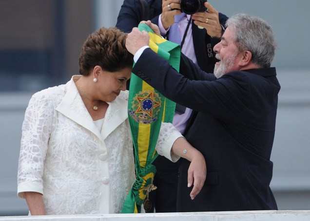 Na posse, em 2011, Dilma Rousseff recebe a nova faixa presidencial das mãos de Lula