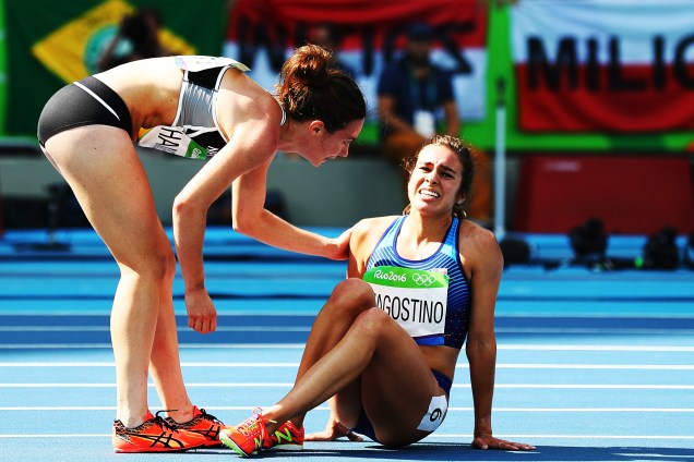 Abbey D'Agostino dos Estados Unidos (à dir.) é ajudada pela neozelandesa Nikki Hamblin depois de uma colisão entre as duas durante a prova dos 5.000 metros rasos