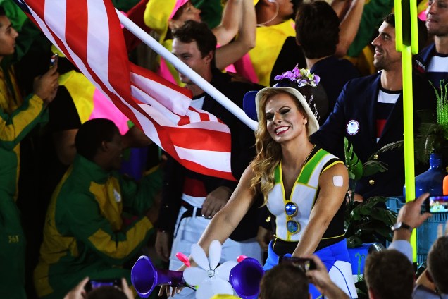 Mulher sorri para fotógrafos durante a abertura dos Jogos Olímpicos no estádio do Maracanã, Rio de Janeiro