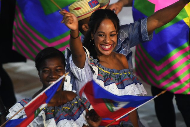 Mulheres sorriem e acenam para fotógrafos durante a abertura dos Jogos Olímpicos no estádio do Maracanã, Rio de Janeiro