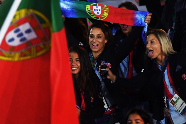 Portuguesas levantam a bandeira do país e acenam para fotógrafos durante abertura da Olimpíada Rio-2016