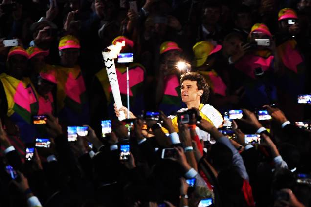 Gustavo Kuerten, o Guga, carrega a tocha com a chama olímpica durante a abertura dos Jogos Olímpicos Rio 2016, no estádio do Maracanã