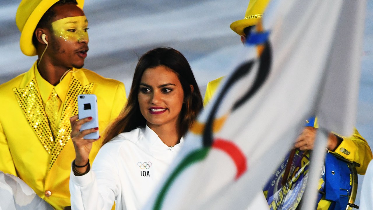 Mulher registra fotos da abertura da Olimpíada em seu celular, no estádio do Maracanã, Rio de Janeiro