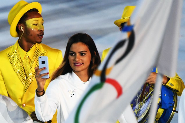 Mulher registra fotos da abertura da Olimpíada em seu celular, no estádio do Maracanã, Rio de Janeiro