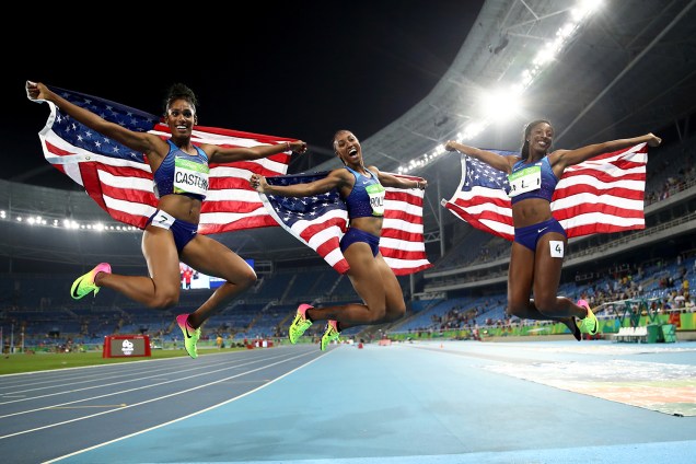Medalhistas Kristi Castlin, de bronze, Nia Ali, de praia e Brianna Rollins, de ouro, todas americanas, comemoram título com bandeira dos Estados Unidos após prova de 100m com obstáculos no Estádio Olímpico