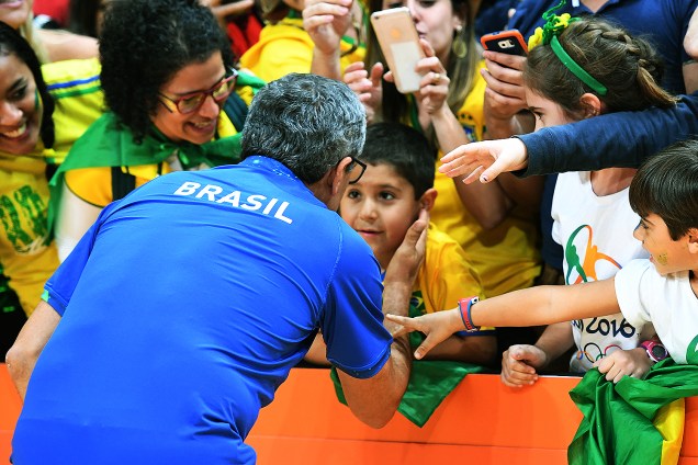 O técnico da seleção feminina de vôlei, José Roberto Guimarães, fala com a torcida após jogo contra o Japão