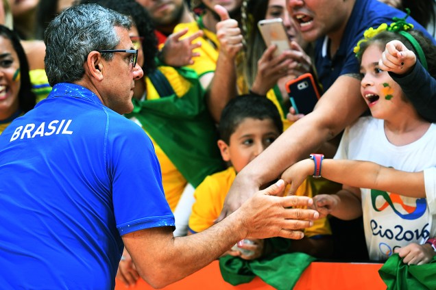 O técnico da seleção feminina de vôlei, José Roberto Guimarães, fala com a torcida após jogo contra o Japão