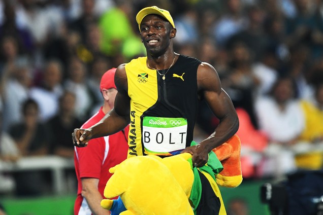Usain Bolt comemora com o mascote Vinícius a conquista do tri olímpico nos 100m rasos