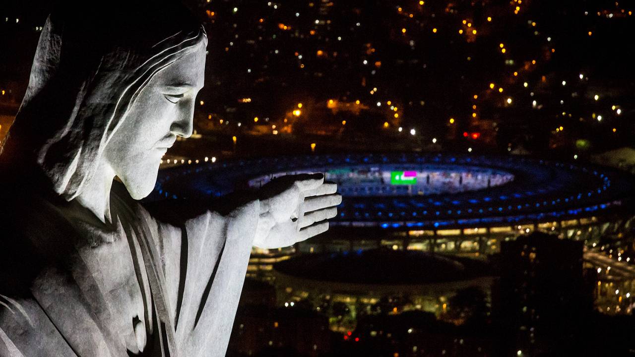 Cristo Redentor é fotografada com estádio do Maracanã ao fundo, durant ensaios para abertura da Olimpíada Rio 2016