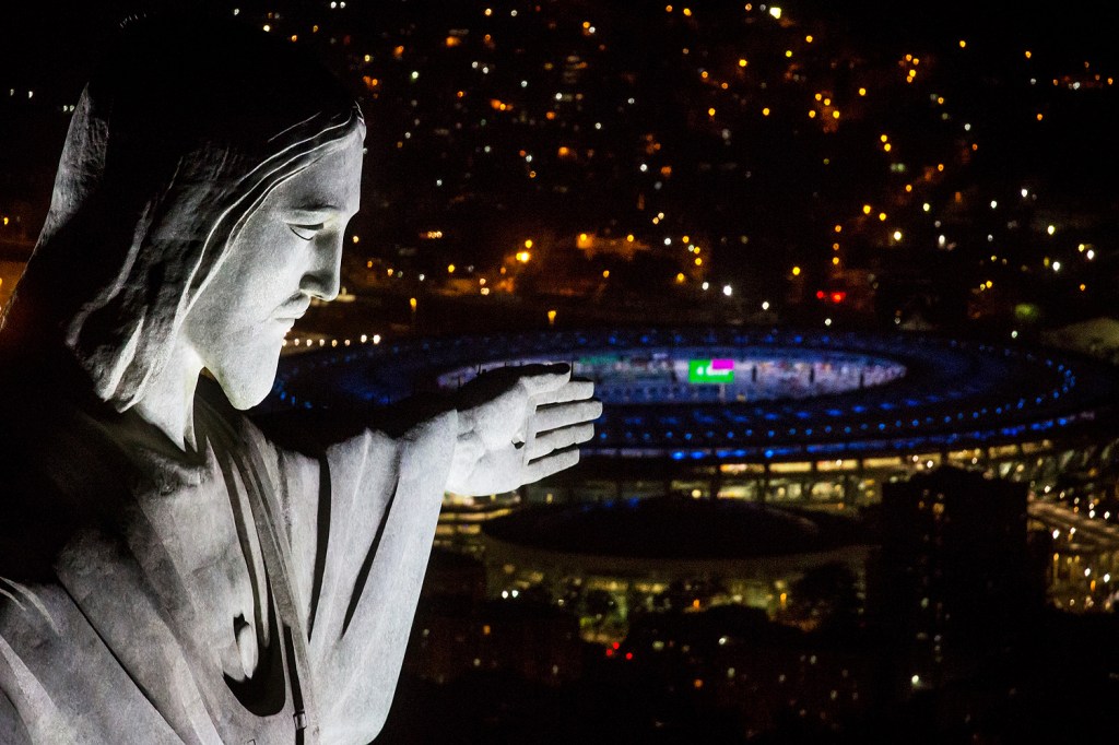 Cristo Redentor é fotografada com estádio do Maracanã ao fundo, durant ensaios para abertura da Olimpíada Rio 2016