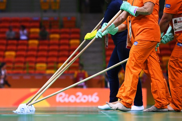 Empregados do Parque Olímpico limpam o piso da quadra de handball, antes da partida entre Croácia e Catar, na Arena do Futuro, no Rio de Janeiro (RJ) - 07/08/2016