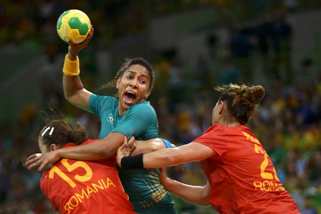 A brasileira Ana Paula Belo, tenta passar pelo bloqueio da seleção de handebol da Romênia