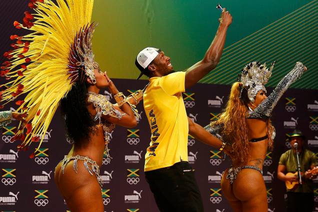 O velocista Usain Bolt dança com passistas durante uma coletiva de imprensa, no Rio