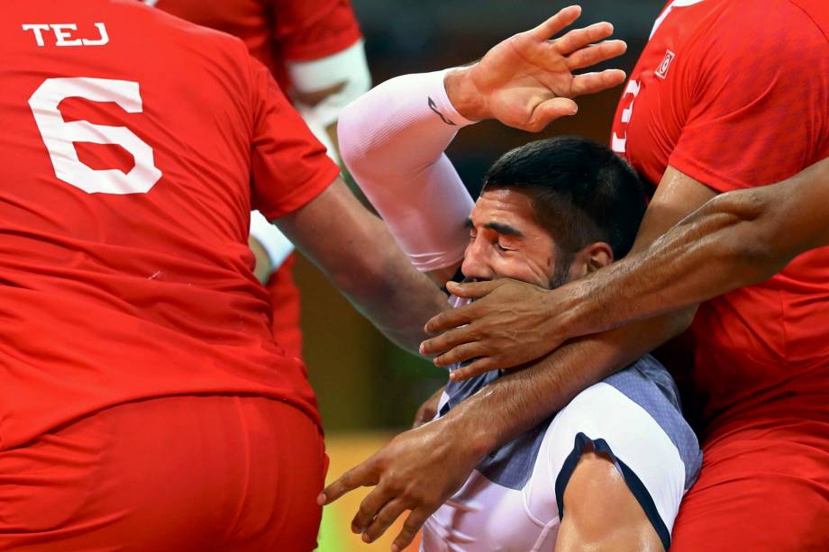 Nikola Karabatic da França é marcado de perto pela defesa tunisiana na disputa do handebol masculino na Arena do Futuro