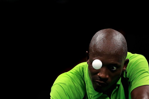 Segun Toriola da Nigéria durante disputa no tênis de mesa contra o japonês Koki Niwa