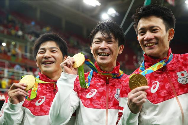 Seleção japonesa de ginástica artística exibe a medalha de ouro após vencer a prova em equipes