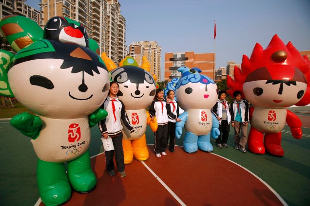 Estudantes posam para foto com os mascotes da Olimpíada de Pequim, na China