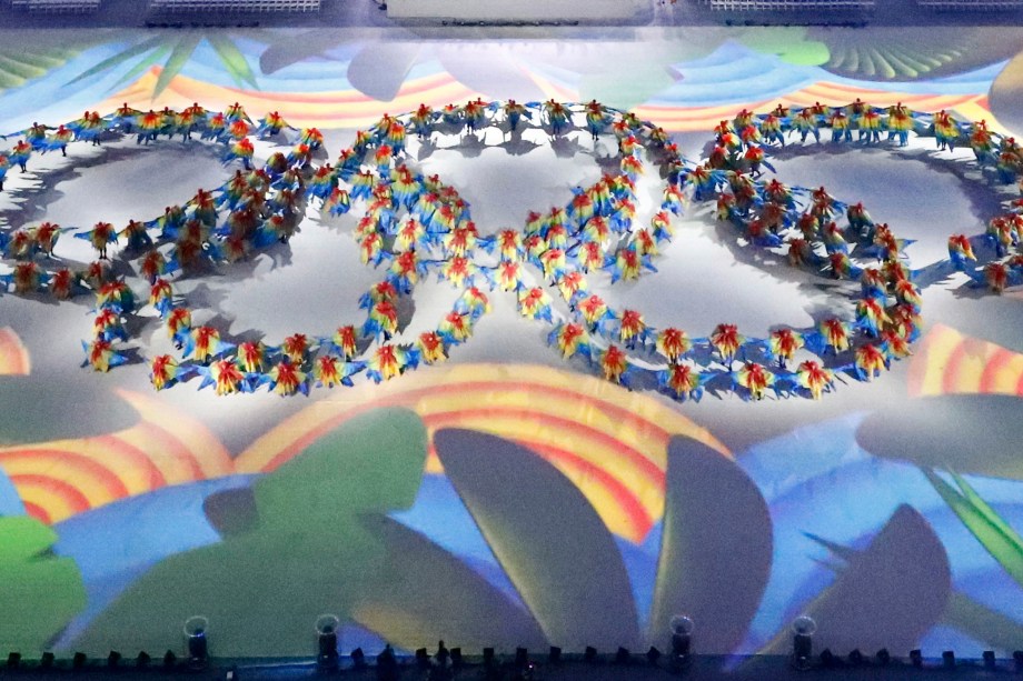 Bailarinos formam os anéis olímpicos no centro do gramado do Maracanã