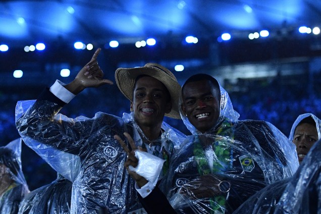 Atletas da delegação brasileira desfilam com capas de chuva durante a cerimônia de encerramento da Rio-2016