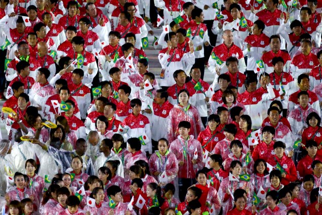 Atletas da delegação japonesa desfilam com capas de chuva durante a cerimônia de encerramento da Rio-2016