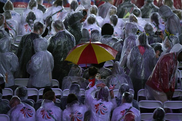 Atletas desfilam com capas de chuva durante cerimônia de encerramento da Rio-2016