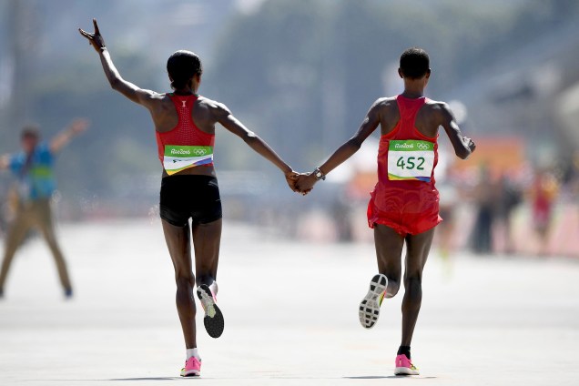 A vencedora da maratona feminina Jemima Sumgong, do Quênia, comemora de mãos dadas com a segunda colocada, Eunice Jepkirui Kirwa, do Bahrein - 14/08/2016