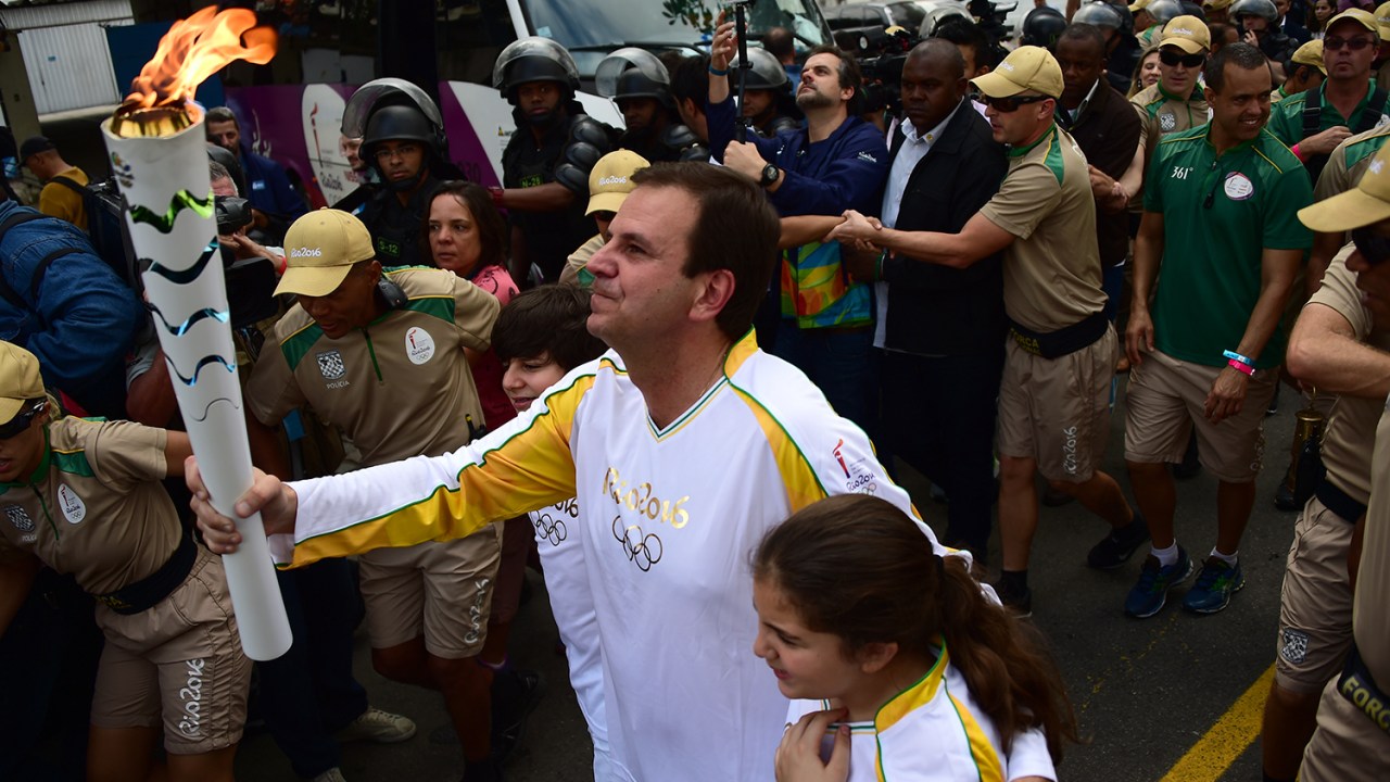 O prefeito do Rio de Janeiro (RJ), Eduardo Paes, carrega a tocha olímpica, durante revezamento - 03/08/2016