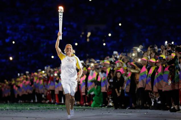 A ex-jogadora de basquete, Hortência, carrega a tocha olímpica, no Maracanã