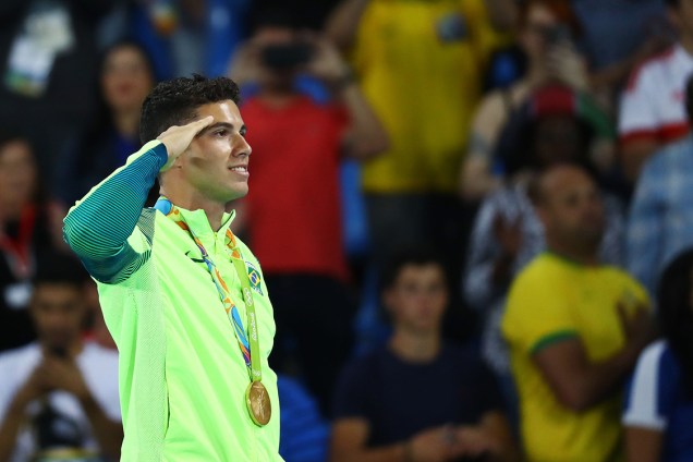 O brasileiro Thiago Braz presta continência no pódio, após conquistar a medalha de ouro no salto com vara, nos Jogos Olímpicos Rio 2016