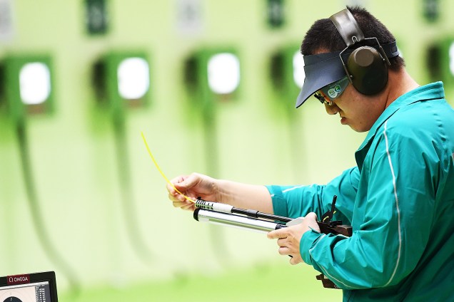 Felipe Wu limpa sua pistola durante competição nos 10m tiro com pistola, no Rio
