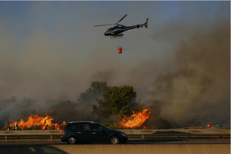 Um helicóptero dos bombeiros combate as chamas no sul da França
