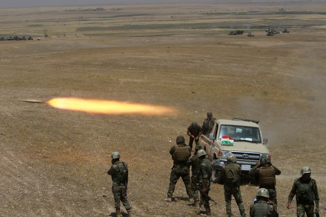 Soldados das forçcas curdas peshmerga lançam um foguete contra militantes do Estado Islâmico, próximo a Mosul , no Iraque