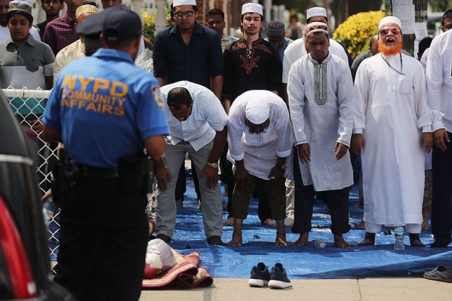Homens rezam em frente a mesquita Al-Furqan Jame Masjid, onde dois muçulmanos foram assassinados, no bairro do Queens, em Nova York