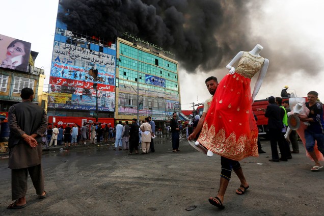 Comerciante afegão carrega manequim, durante incêndio em um shopping center em Cabul, capital do Afeganistão - 04/08/2016