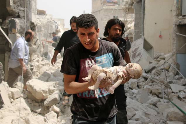 Morador sírio carrega um bebê morto retirado dos escombros de edifícios depois de um ataque a bomba no bairro de Bab al-Nairab na cidade síria do norte de Aleppo – 25/08/2016