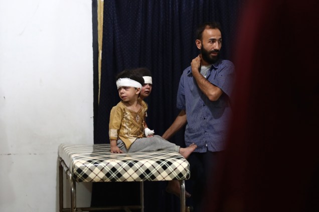 Crianças feridas recebem tratamento em um hospital improvisado na sequência de um ataque aéreo na cidade controlada pelos rebeldes de Douma, na Síria - 23/08/2016
