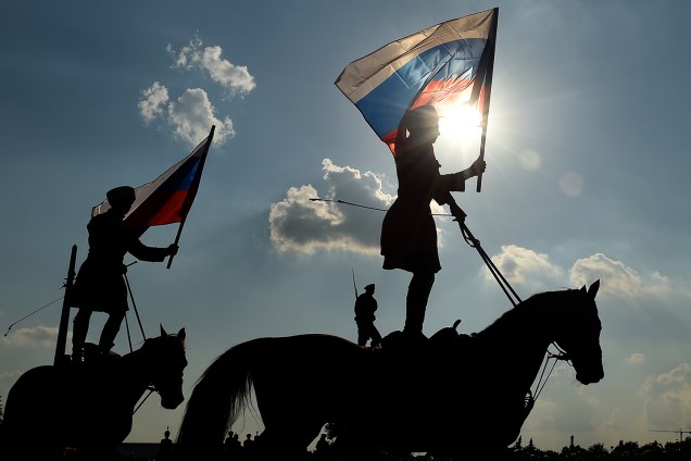 Cavaleiros carregam a bandeira da Rússia durante as comemorações do Dia da Bandeira, em Moscou - 22/08/2016