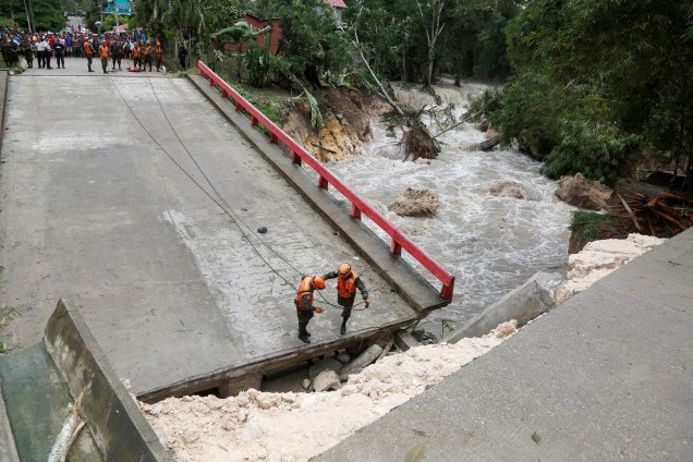 Os membros da comissão de emergência da Guatemala trabalham em uma ponte que desabou após as fortes chuvas provocadas pelo furacão Earl na cidade de Menchor de Mencos - 04/08/2016