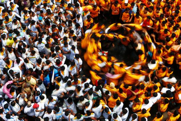 Devotos dançam em círculos após quebrarem uma panela de barro contendo coalhada, durante o Festival Janmashtami, em Mumbai, na Índia - 25/08/2016