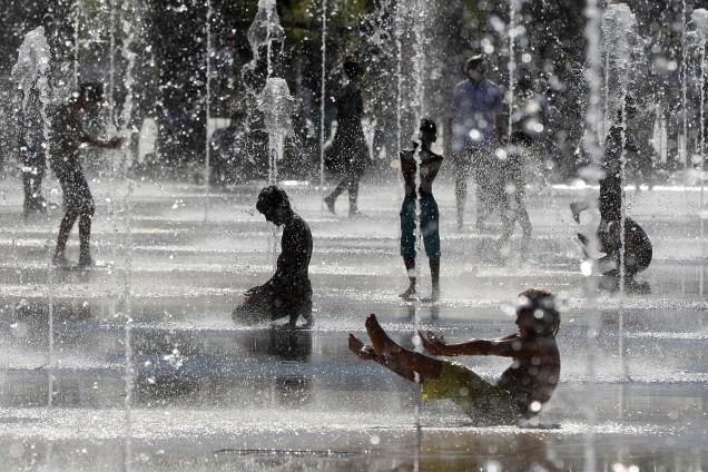 Crianças brincam e se refrescam em um fonte na cidade de Nice, na França, durante um dia quente de verão - 23/08/2016