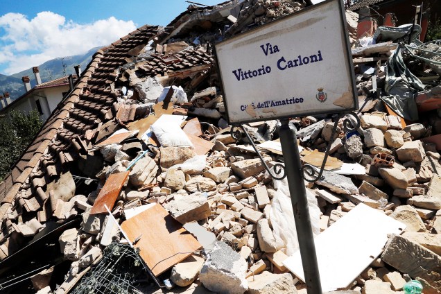 Placa de estrada é vista próxima de uma casa destruída pelo terremoto que atingiu a cidade de Amatrice, na Itália - 26/08/2016