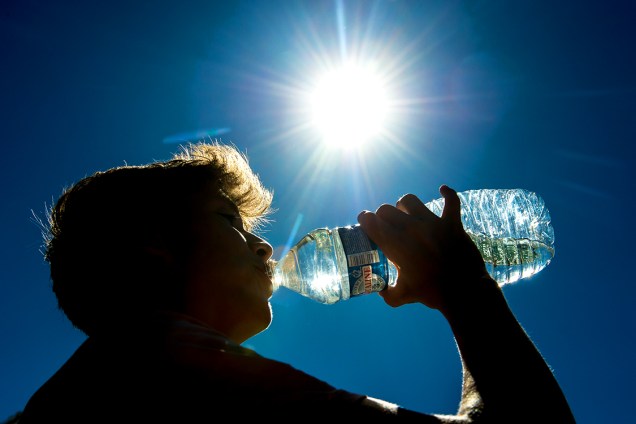 Homem se refresca bebendo água em um dia quente de verão na França - 24/08/2016