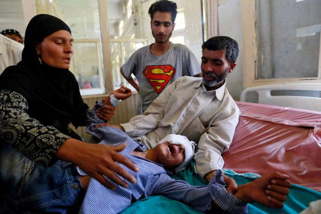 Os pais tentam confortar seu filho ferido durante confronto com forças de segurança em Srinagar durante onda de violência na região Caxemira, em Srinagar, na Índia - 18/06/2016