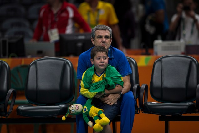O técnico José Roberto Guimarães com o neto após derrota da seleção feminina de vôlei nas quartas de finais contra a China, no Maracanazinho