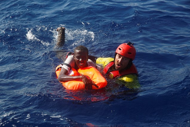 Membro da organização espanhola Proactiva, resgata um imigrante da Somália, ao largo da costa da Líbia no mar Mediterrâneo