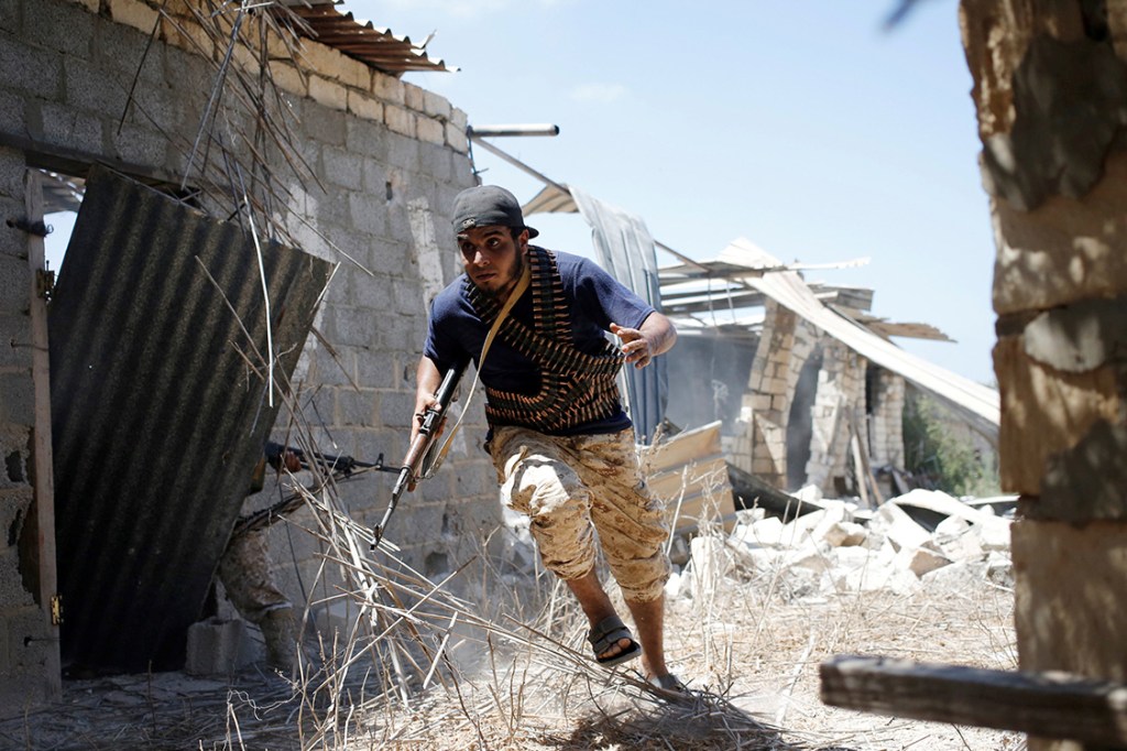 Soldado da Força Líbia, apoiada pela ONU, tenta se proteger durante confronto com o Estado Islâmico, em Sirte, na Líbia